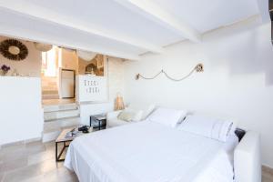 a white bedroom with a white bed and a couch at Casa Zio Piero in Ostuni