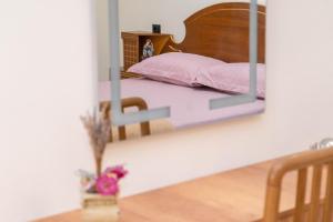 a mirror reflecting a bed in a bedroom at Spacious & Relaxing Home with Free Parking in Vlorë