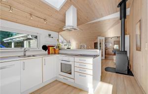 a kitchen with white cabinets and a wood ceiling at Holiday Home Dyssebjergvej Rømø Denm in Rømø Kirkeby
