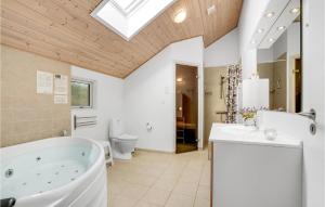 a bathroom with a tub and a sink and a toilet at Holiday Home Dyssebjergvej Rømø Denm in Rømø Kirkeby +25 photos