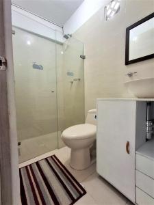 a bathroom with a toilet and a glass shower at Northwest Hostings 301 in Cartagena de Indias