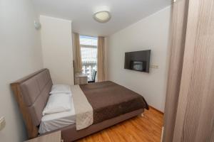 Un dormitorio con una cama y un televisor de pantalla plana. en Panoramic view, en Batumi