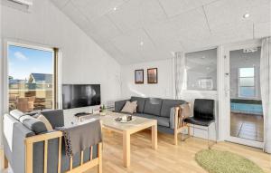 a living room with a couch and a table at 4 Bedroom Amazing Home In Hvide Sande in Bjerregård