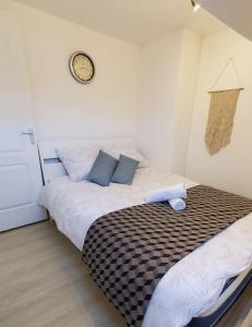a bedroom with a bed with a clock on the wall at Maison de ville Marcq en Baroeul in Marcq-en-Baroeul