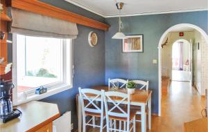 a kitchen and dining room with a table and chairs at Amazing Home In Nordtveitgrend in Haugen