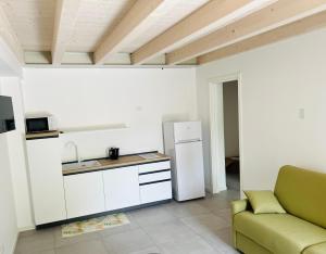 a kitchen with a refrigerator and a couch in a room at Le Casette Uno in Pacengo di Lazise