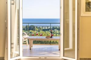 an open door to a balcony with a table with wine glasses at Liogerma Art Deco Villa - 5 min drive to Lassi in Sarláta +62 photos