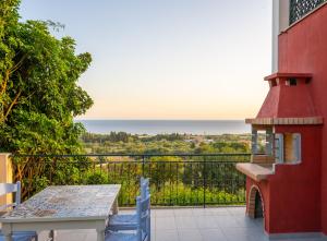 a balcony with a table and a view of the ocean at Liogerma Art Deco Villa - 5 min drive to Lassi in Sarláta