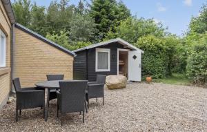 a table and chairs in front of a tiny house at Cozy Home In Spøttrup With Sauna in Spottrup +18 photos