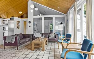 a living room with couches and a table and chairs at Cozy Home In Spøttrup With Sauna in Spottrup