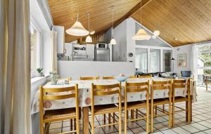 a dining room and kitchen with a table and chairs at Cozy Home In Spøttrup With Sauna in Spottrup