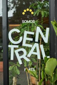 un cartel en una puerta de cristal con una planta en The Somos Central Hotel Poblado, en Medellín