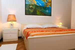 a bedroom with a bed and a painting on the wall at Apartments Villa Ada in Vinkuran