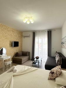 a bedroom with a bed and a couch and a television at Apartmens Xhenis Lux in Ulcinj +76 photos