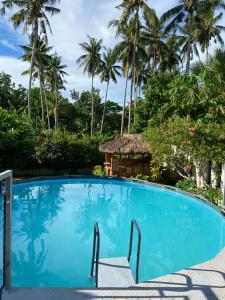 a swimming pool with a gazebo and palm trees at 4 Bedrooms Guesthouse with Pool and Mangrove Park in Alburquerque