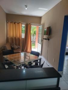 ein Wohnzimmer mit Tisch und Couch in der Unterkunft Casa de praia para temporada in Paulista