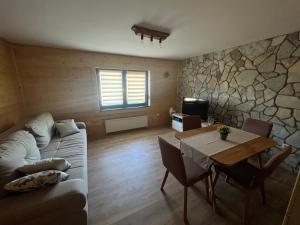 a living room with a couch and a table at Zen Den apartments in Otočac