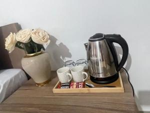 a table with a coffee pot and cups and roses at Hotel Majestic in Struga