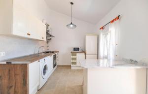 a kitchen with white cabinets and a counter top at Nice Home In Benajarafe With Wifi in Benajarafe