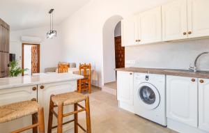 a kitchen with white cabinets and a washing machine at Nice Home In Benajarafe With Wifi in Benajarafe +8 photos