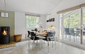 a dining room with a table and chairs and a fireplace at 3 Bedroom Stunning Home In Vig in Vig