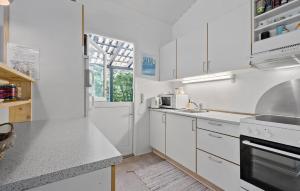 a white kitchen with white cabinets and a window at 3 Bedroom Stunning Home In Vig in Vig
