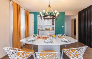 a dining room with a white table and chairs at 4 Bedroom Cozy Home In Mihatovici in Rošini