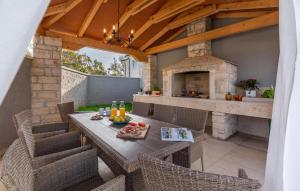an outdoor patio with a table and a stone oven at 4 Bedroom Cozy Home In Mihatovici in Rošini