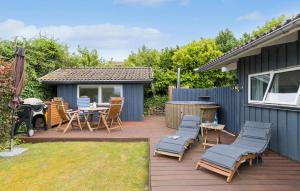 a patio with chairs and a table and a grill at 3 Bedroom Lovely Home In Ebeltoft in Ebeltoft +10 photos