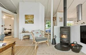 a living room with a fireplace and a chair at 3 Bedroom Lovely Home In Ebeltoft in Ebeltoft