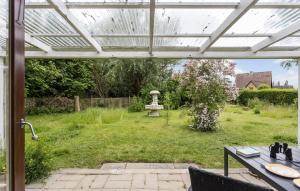 a patio with a white pergola and a garden at 3 Bedroom Awesome Home In Tranekær in Tranekær +11 photos