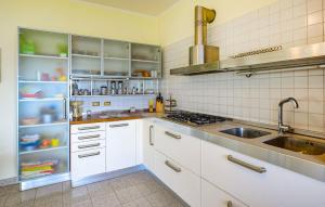 a kitchen with white cabinets and a sink at 2 Bedroom Nice Apartment In Orbetello in Orbetello