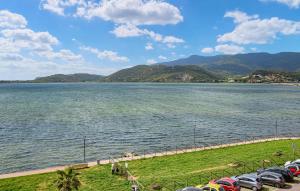 a row of cars parked next to a large body of water at 2 Bedroom Nice Apartment In Orbetello in Orbetello +14 photos