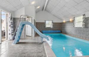 a indoor swimming pool with a slide in a room at Pet Friendly Home In Sydals With Sauna in Sønderby +23 photos