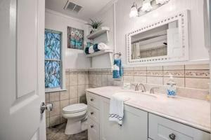 a bathroom with a sink and a toilet and a mirror at Charming 4-Bedroom Family Haven in Saint Augustine