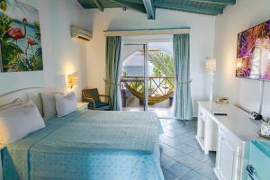 una camera da letto con un letto e un balcone con vista sull'oceano di Ocean Point Beach Resort & Spa Adults Only a Saint John's