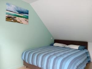 a bedroom with a bed with a painting on the wall at Maison au calme à l'intérieur du golf de Ploëmel, entre terre et mer, 2 chambres, 10 min des plages in Ploemel +28 photos
