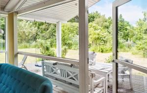 博托比Amazing Home In Væggerløse With Wifi的一个带蓝色沙发和桌子的屏蔽门廊 更多9张照片