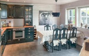 a kitchen with a table with a lion picture on the wall at 3 Bedroom Beautiful Home In Åseral in Åseral
