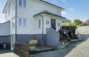 a white house with a wooden porch and stairs at Cozy Home In Hellvik With Wifi in Hellvik +18 photos