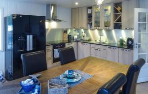 a kitchen with a wooden table and a black refrigerator at Cozy Home In Hellvik With Wifi in Hellvik