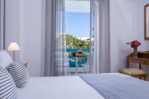 1 dormitorio con cama y ventana con vistas en Santellini Hotel, en Kamari