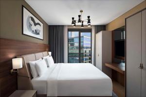 a bedroom with a large white bed and a window at Radisson Residences Vadistanbul in Istanbul