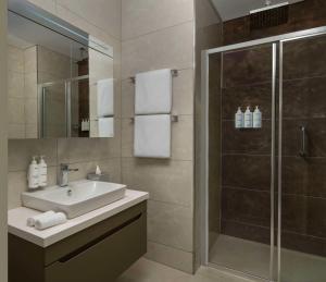 a bathroom with a sink and a shower at Radisson Residences Vadistanbul in Istanbul