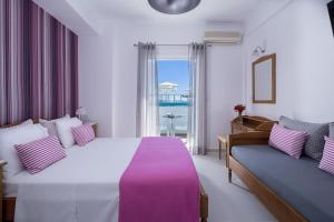 una camera d'albergo con un letto grande e un divano di Santellini Hotel a Kamari