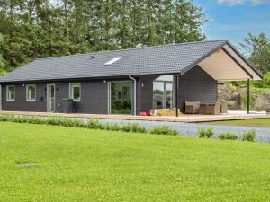 a gray house with a porch and a lawn at 5 star holiday home in Ansager-By Traum in Ansager