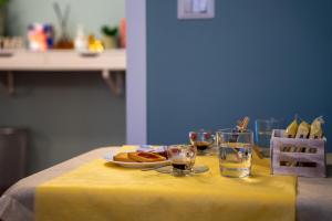 a table with a plate of food and glasses of water at City Love Rooms in Siracusa