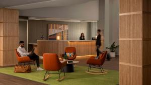 休斯顿Spark By Hilton Houston Bush Intercontinental Airport的大厅里，一名男子坐在候诊室的椅子上