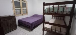 a bedroom with a bunk bed and a window at Casa temporada no Indaiá com wi-fi e churrasqueira in Caraguatatuba