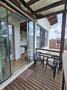 a patio with two chairs and a table on a deck at Casa da Flor Guest House – Praia Grande – Beto Carrero in Penha
